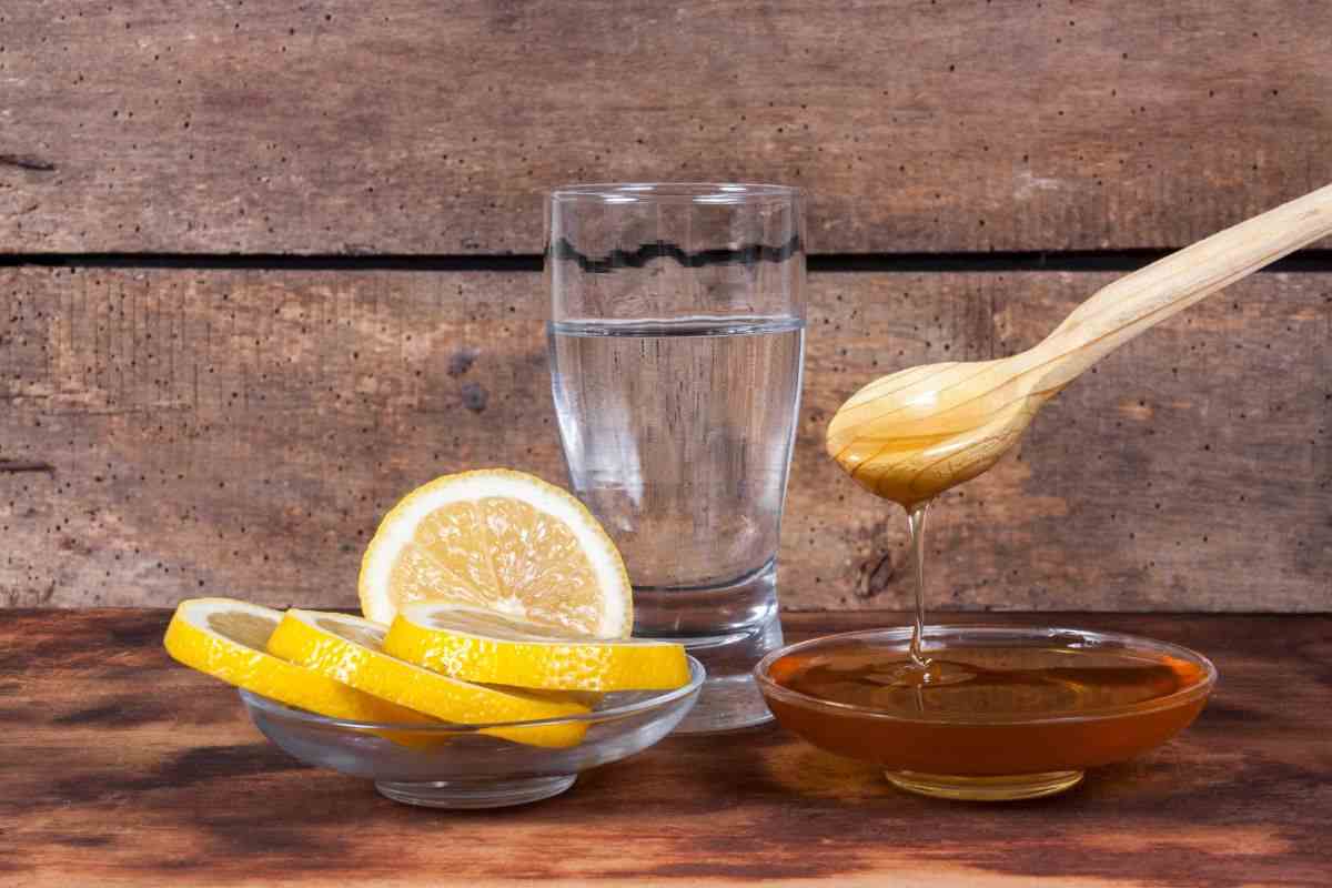 Bicchiere d'acqua con fette di limone e miele